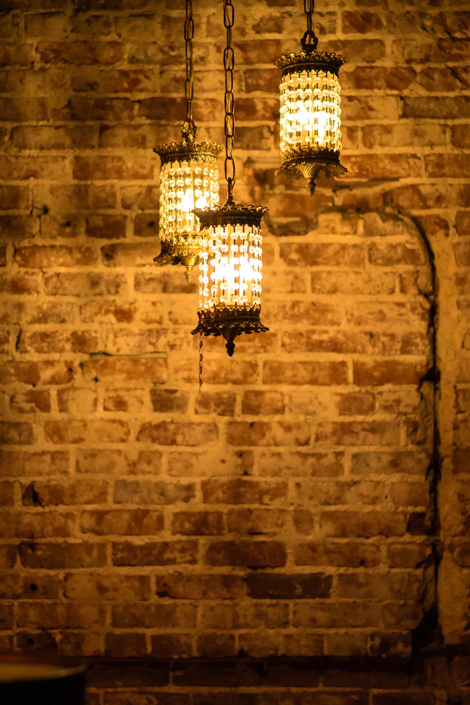 Crystal lamps hanging against the original brick wall