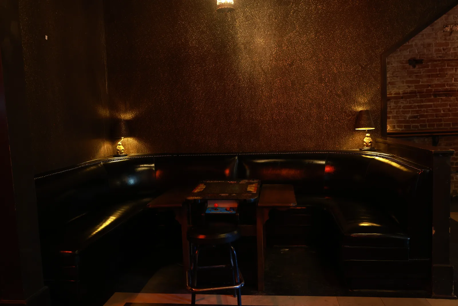 A black leather booth in the corner, lit low